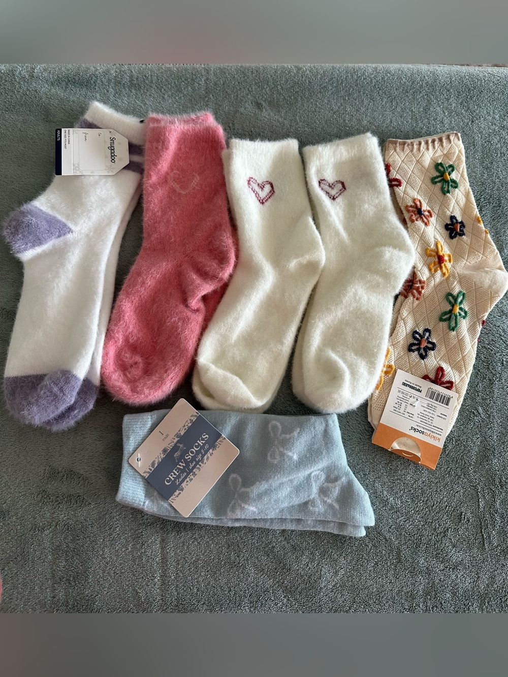 Six pairs of socks , 4 pairs are fuzzy, and 2 pairs are floral y light blue.